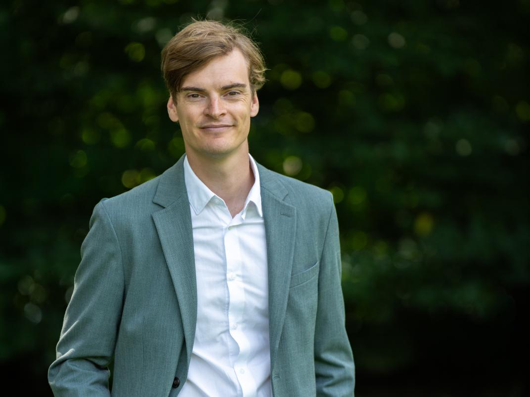 Portretfoto wethouder Lennart de Looze in kostuum met hand in zakken