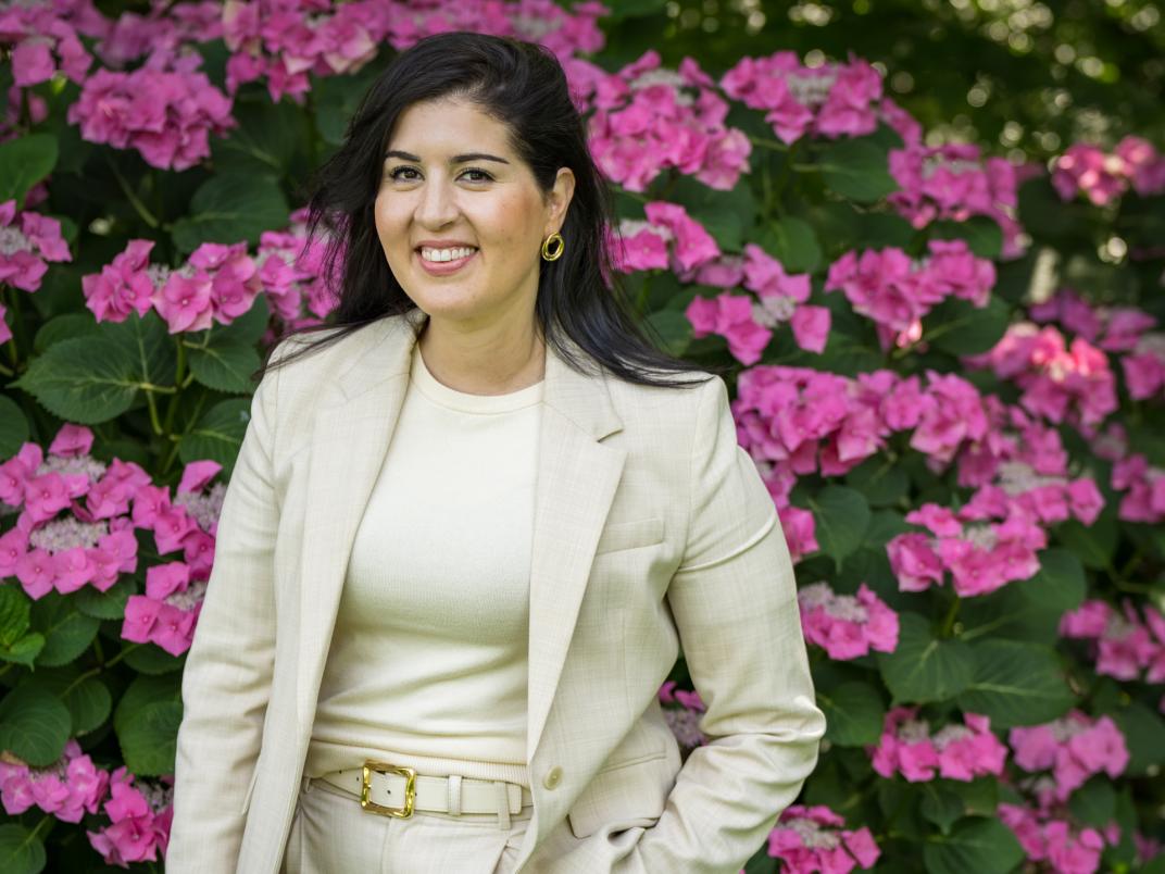 Portretfoto wethouder Saloua Chaara in creme kostuum voor bloemen